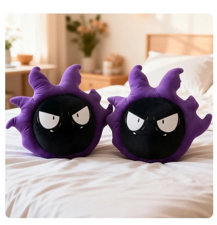 Pokemon Gastly Plush Pillow Stuffed Toy Two purple and black plush pillows shaped like cartoon shadow creatures, placed side by side on a white bed in a softly lit bedroom.