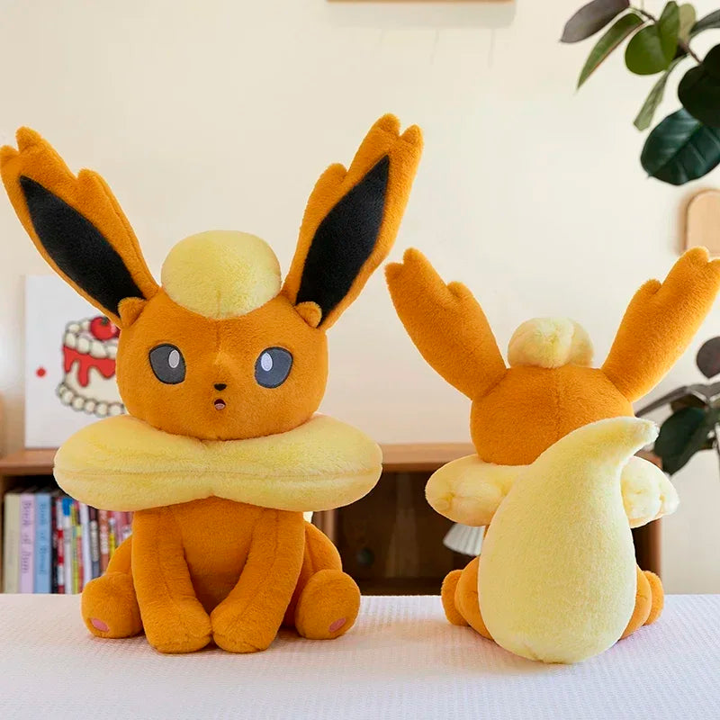 Pokemon Eevee Plush Toy – Vaporeon, Flareon & Jolteon Soft Stuffed Animal Two plush toys resembling Eevee from Pokémon on a table with a blurred indoor background.