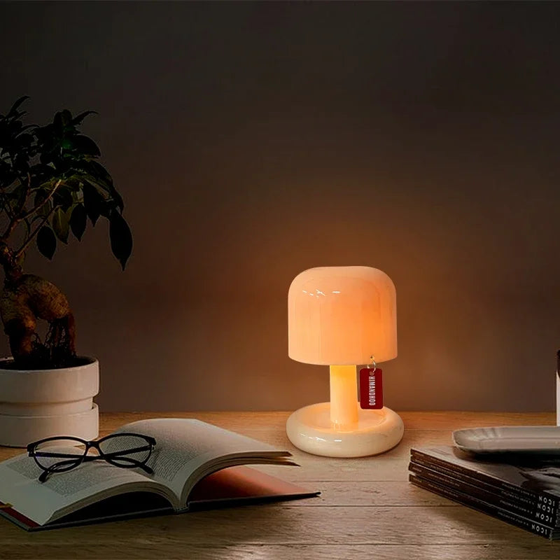 Orange Mushroom LED Night Light – Nordic Minimalist Table Lamp Small lamp on a table with an open book and glasses, creating a warm glow.