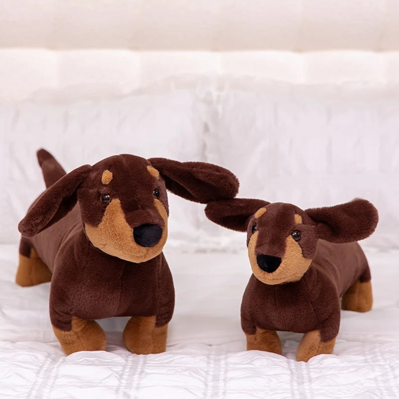 Realistic Dachshund Plush Dog Stuffed Animal Two brown plush dachshunds on a white blanket