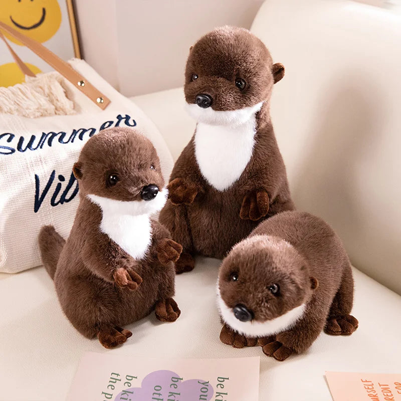 Realistic Otter Plush Toy Three plush otters sitting on a surface with a 'Summer Vibes' pillow in the background.