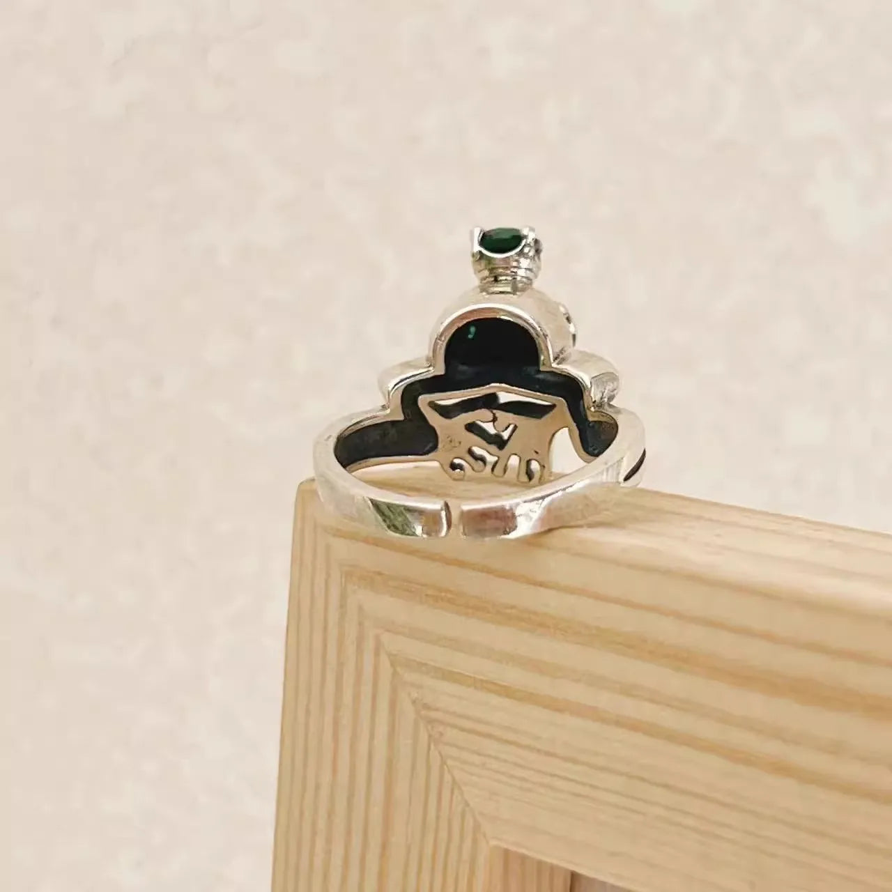 925 Silver Frog Crown Ring – Retro Adjustable Statement Jewelry Silver ring with a green gemstone on a wooden stand against a beige background