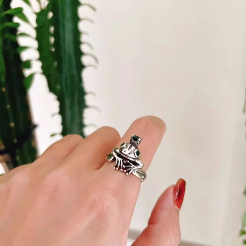 925 Silver Frog Crown Ring – Retro Adjustable Statement Jewelry Silver ring with black gemstones on a finger against a blurred indoor background