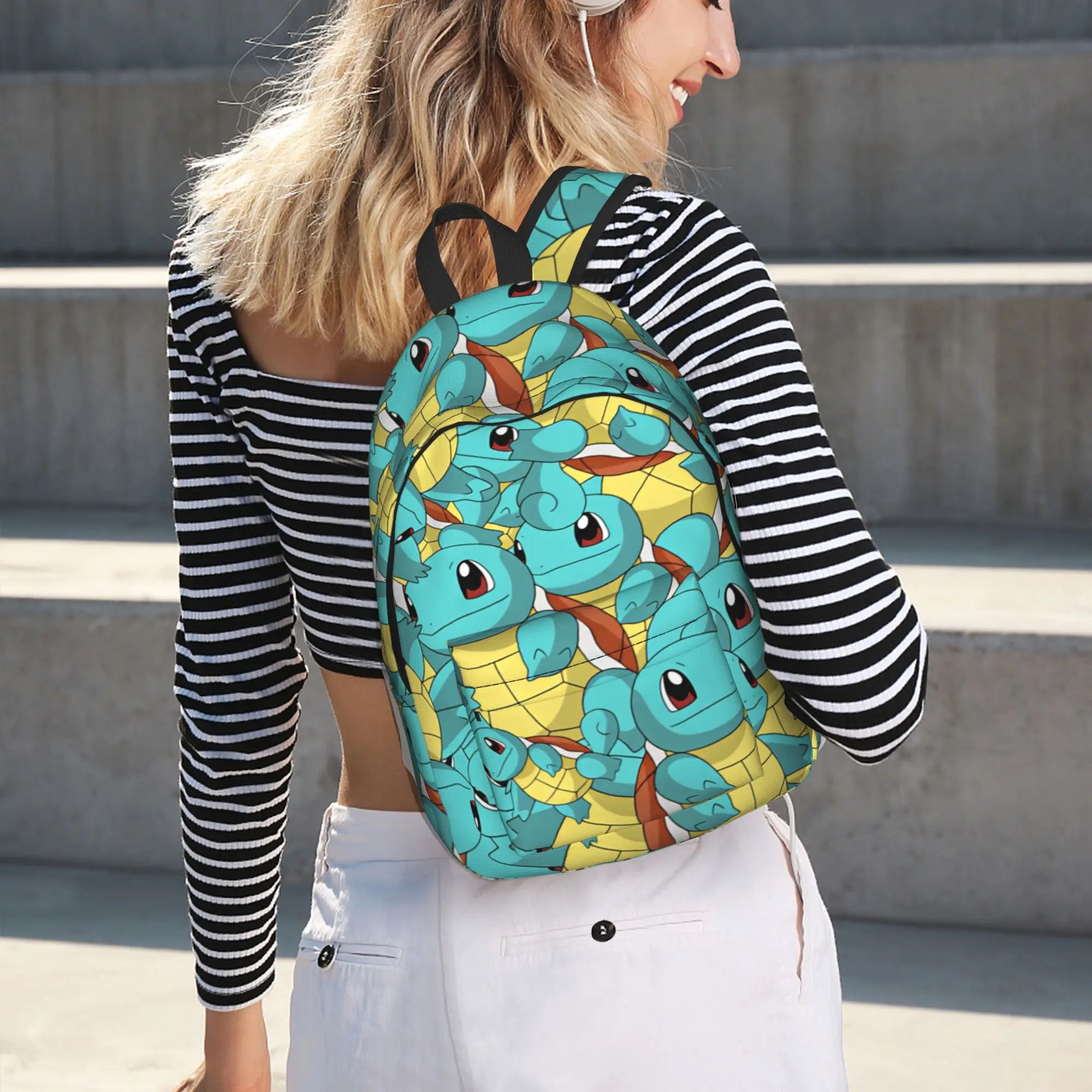 Pokemon Squirtle Backpack – Sport School Bag A woman wearing a black and white striped long-sleeve crop top and white pants, shown from the back, wearing a light blue and yellow Squirtle patterned backpack on concrete steps.