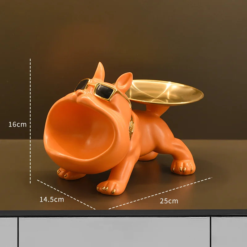 Bulldog Figurine with Storage Box – Resin Dog Home Decor Sculpture Orange dog-shaped object with a gold dish on a dark surface, showing measurements.
