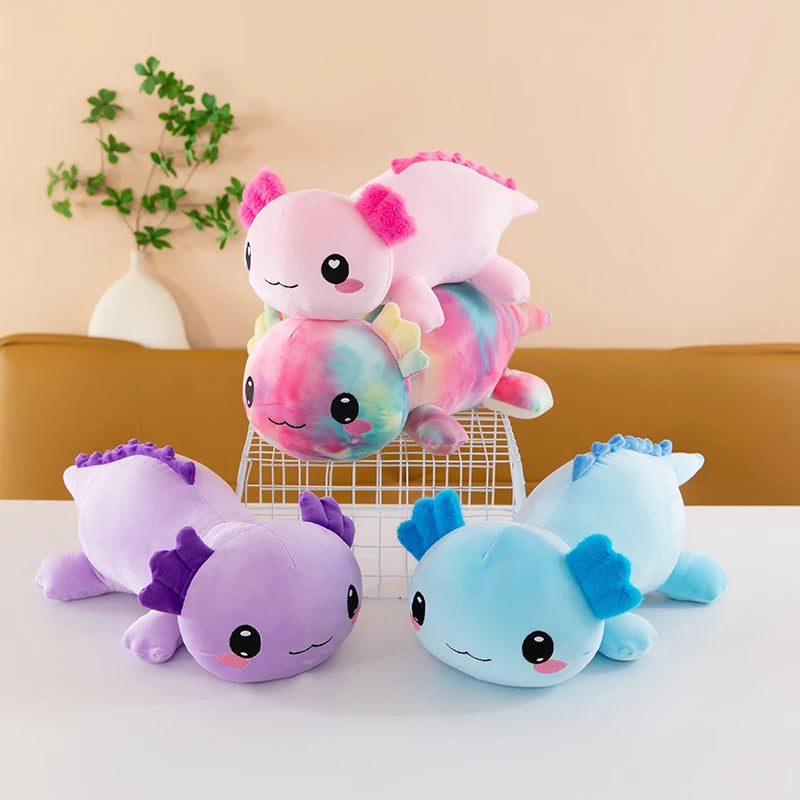 Axolotl Squishmallow Plush – Stuffed Animal Toy Set of colorful axolotl plush toys on a white surface with a beige wall and plant in the background.