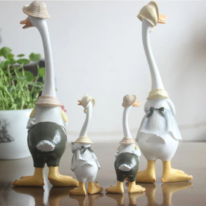 Resin Duck Family Garden Statue – Animal Outdoor Decor Sculpture Set of decorative goose figurines with hats on a light background