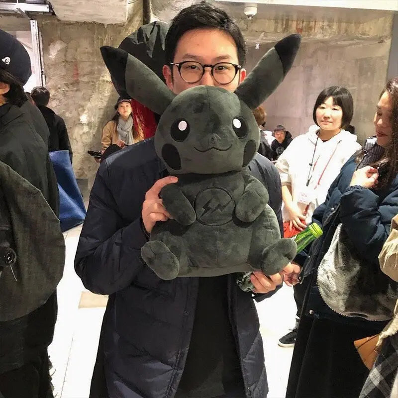 Dark Pikachu Plush Pillow Black Kawaii Doll Person holding a plush toy in an indoor setting with other people around
