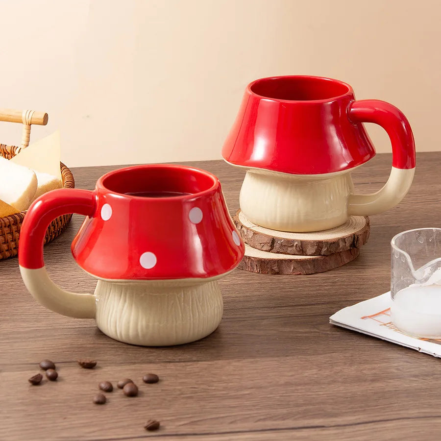 Premium Mushroom Coffee Cup – Large Ceramic Mug Two red and beige mushroom-shaped mugs on a wooden surface with coffee beans.