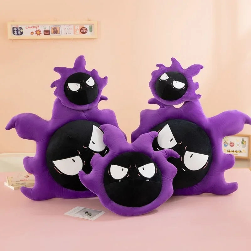 Pokemon Gastly Plush Pillow Stuffed Toy Three purple and black ghost-shaped plush pillows arranged together on a pink surface against a peach wall.