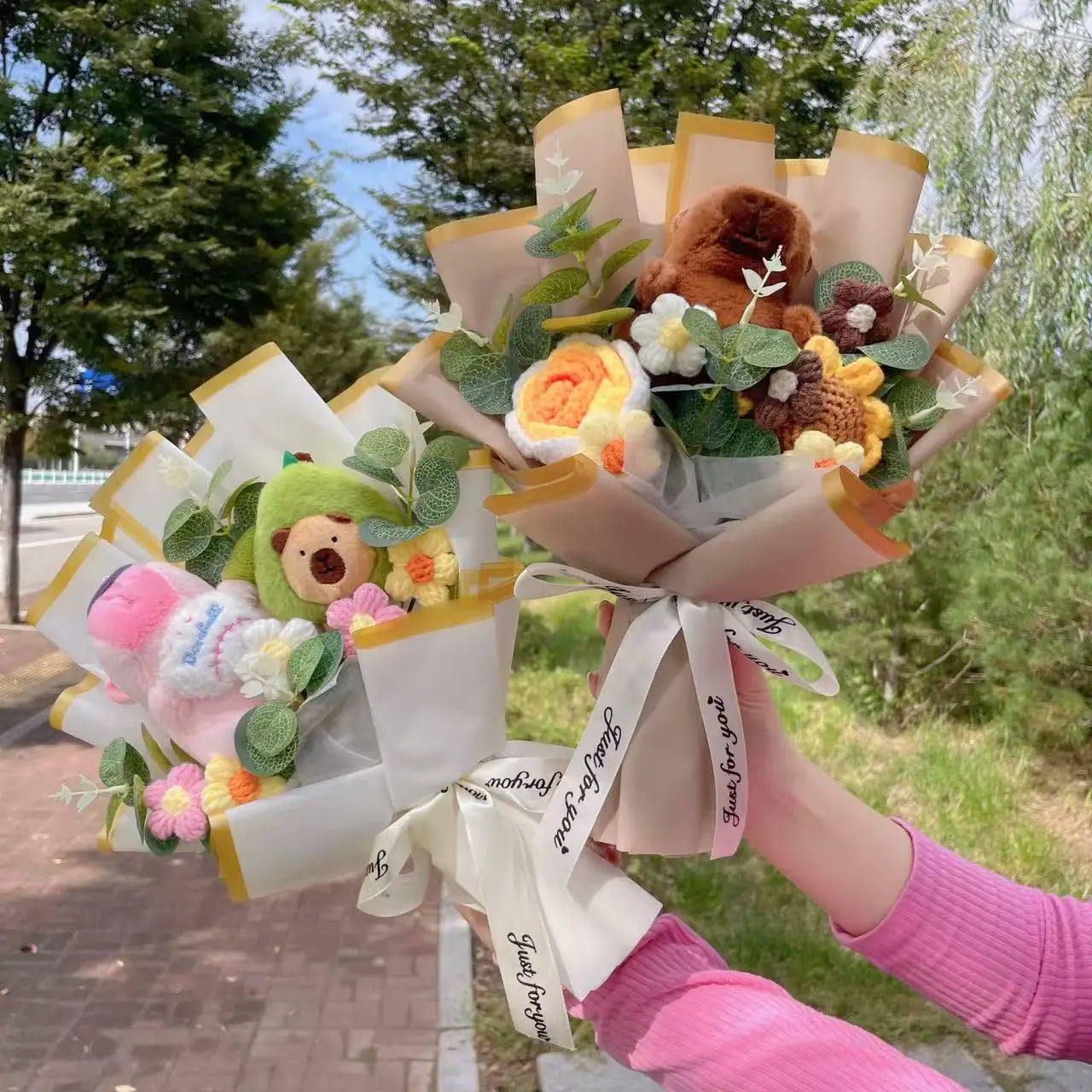 Capybara Plush with Crochet Flowers – Cute Flower Bouquet Gift Bouquet made of plush toys and flowers held outdoors with greenery in the background