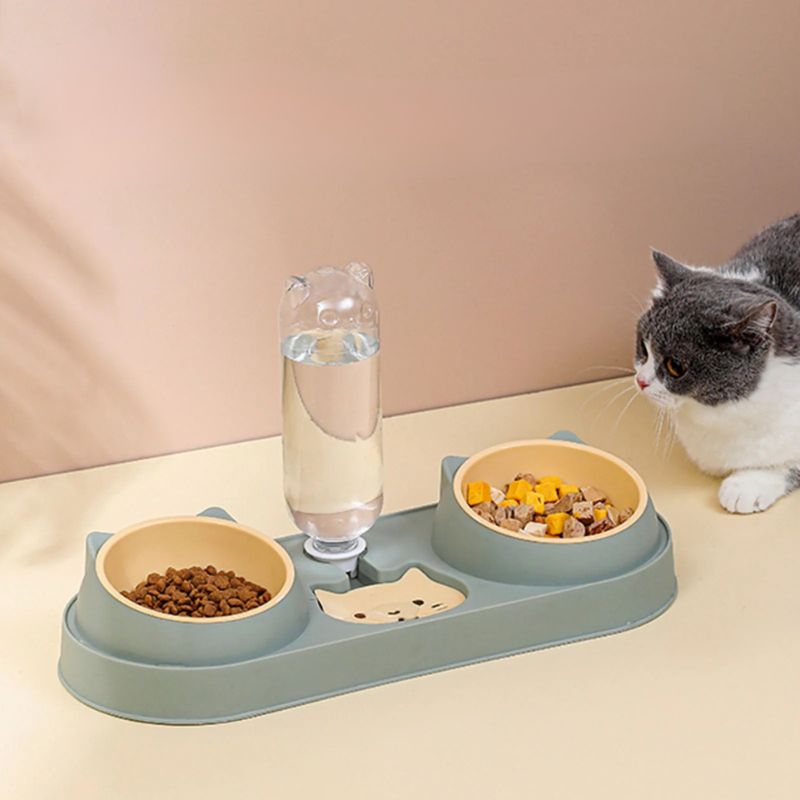 Automatic Pet Feeder Double Bowl with Water Fountain Pet feeding station with two bowls and a glass of water, cat sitting nearby.