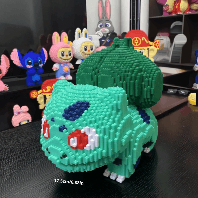 Pokemon Bulbasaur & Charmander Building Blocks – DIY Model Toy A green and teal block-built toy resembling Bulbasaur from Pokémon, displayed on a black tabletop with other colorful toy figures in the background.