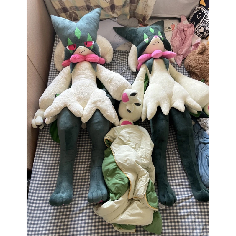 Pokemon Meowscarada Plush Pillow Stuffed Toy Two large plush cat dolls resembling Charizard and a smaller plush figure, arranged on a bed with a checkered blanket. A folded cream and green blanket or garment lies in the foreground.