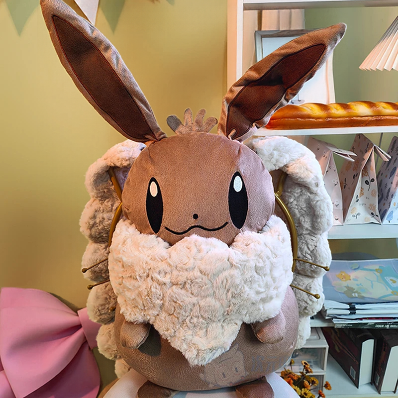 Eevee Plush Backpack – Kawaii Pokemon Cosplay Bag A plush toy of a brown bunny-like character with long upright ears, a fluffy cream scarf, and soft tan fabric body, photographed indoors against a light wall with shelves in the background.
