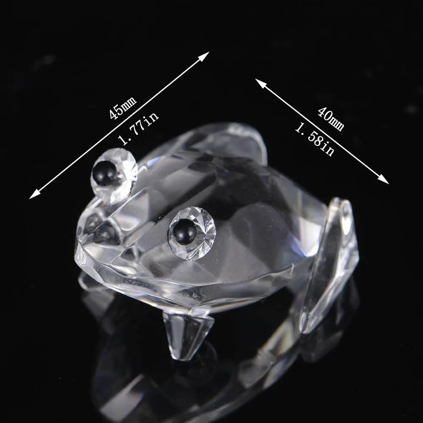 Clear crystal frog figurine with measurements on a black background