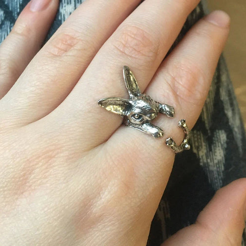 Silver rabbit-shaped ring on a person's finger