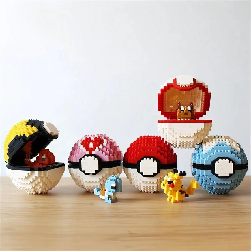 A set of block-built Pokéball-style egg-shaped toys arranged on a light wood surface against a plain white wall. The collection includes several eggs in different colors and patterns, with one open egg showing a red-and-white Pokémon character inside and two small toy figures in front.