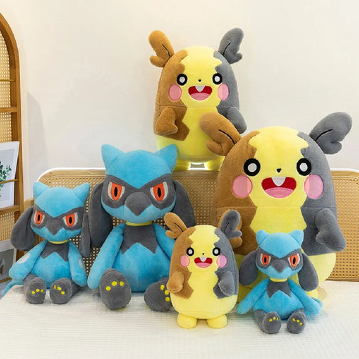 A set of five Pikachu plush toys in different sizes arranged together on a light-colored surface against a neutral indoor background.