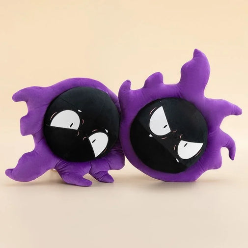 Two purple ghost-shaped plush pillows with black circular faces and white eyes, shown side by side on a plain beige background.