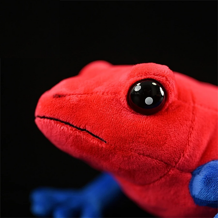 Close-up of a red plush toy with a black eye on a black background
