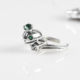 Silver ring with green gemstones on a white background