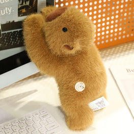 Brown teddy bear plush toy on a desk with a computer keyboard in the background