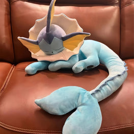 Plush toy resembling a dragon-like creature on a brown leather couch