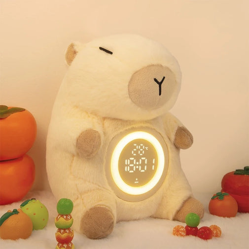 Plush bear clock with digital display surrounded by small fruits and candies on a light background