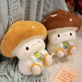 Two plush mushroom toys with bee characters on a textured surface.