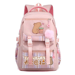 A pink school backpack with cute cartoon graphics, including a capybara holding a bubble tea cup and the text 'Capydara 卡巴拉' on a plaid pocket. It features a fluffy pink pom-pom charm and adjustable straps, shown against a plain white background.