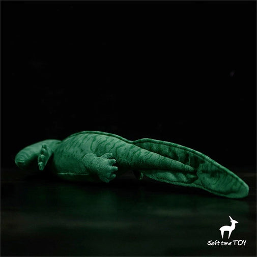Glowing green dinosaur toy on a black background