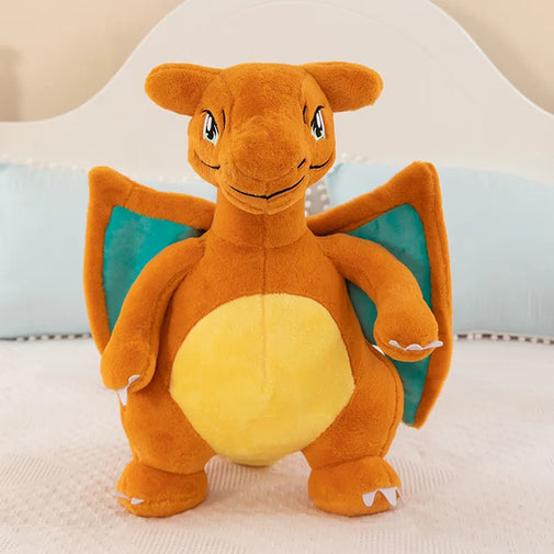 A Charizard plush toy sitting upright on a white textured surface, with a soft white and light blue background.