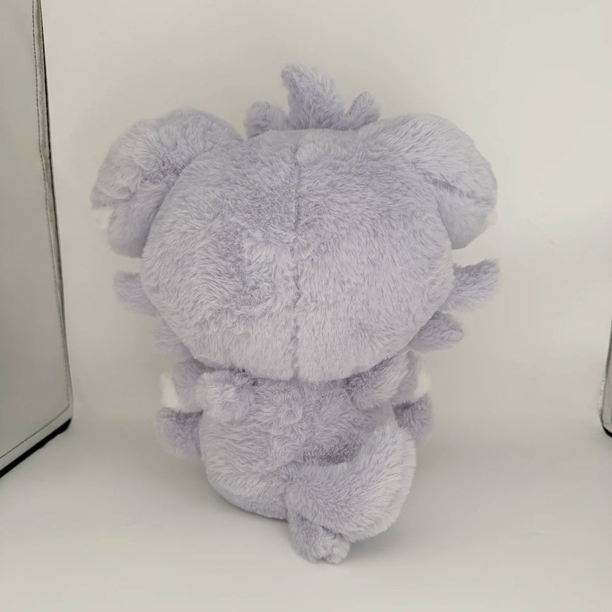 A light purple plush toy shaped like a cute, round character with soft fluffy texture, photographed from the back against a plain white background.