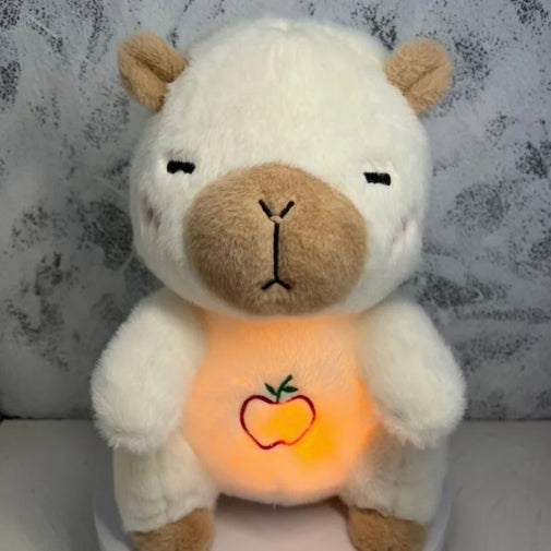 Plush toy with glowing orange belly featuring an apple design against a textured gray background.
