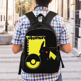 A person viewed from behind wearing a black backpack with a large yellow and black Pokémon graphic on the back, standing outdoors on a city sidewalk.
