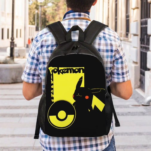 A person viewed from behind wearing a black backpack with a large yellow and black Pokémon graphic on the back, standing outdoors on a city sidewalk.