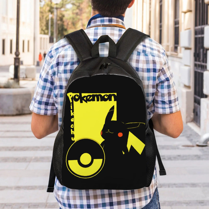 A person viewed from behind wearing a black backpack with a large yellow and black Pokémon graphic on the back, standing outdoors on a city sidewalk.